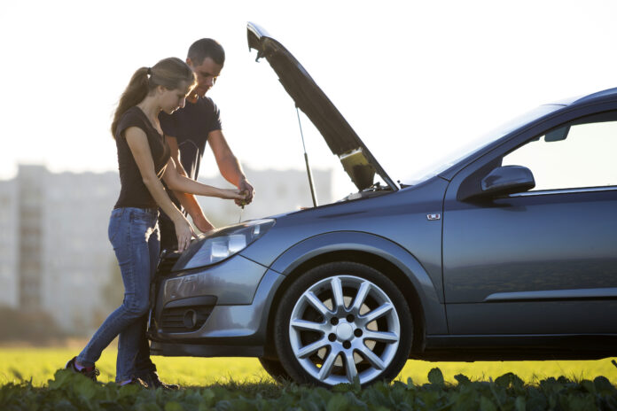 Casal verificando o motor do carro para prolongar sua vida útil