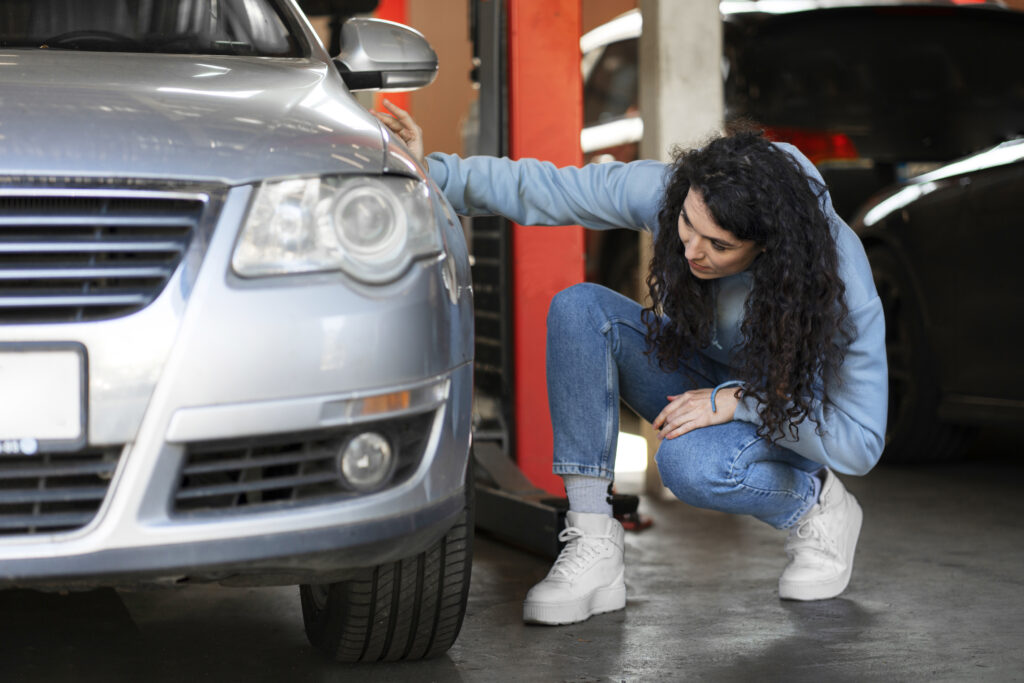 Mulher inspecionando o carro na oficina para manutenção preventiva