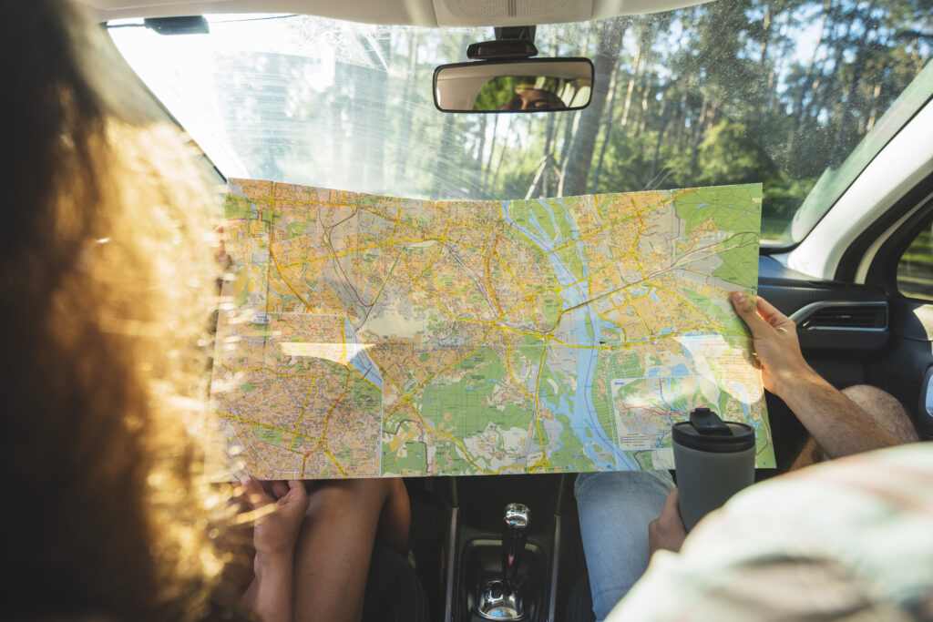 Pessoas olhando um mapa enquanto viajam de carro.